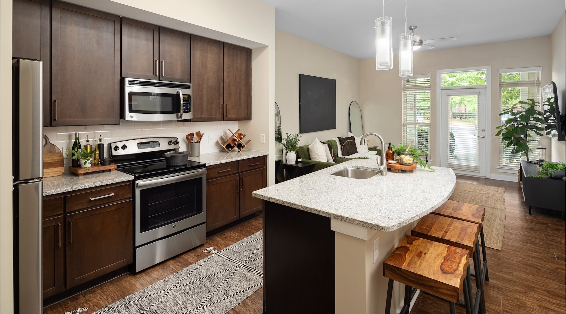 a large kitchen with an island and dark cabinets